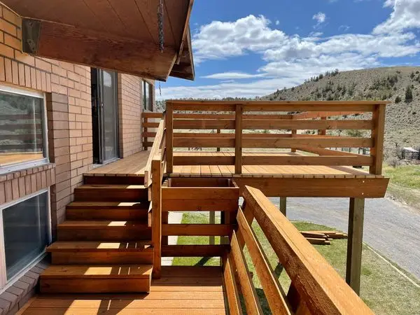 Elevated wood deck and railing system with stairs overlooking Wyoming landscape, built by Bald Ridge Enterprises.